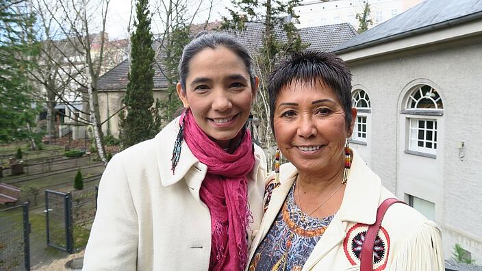 A portrait picture of two middle-aged indigenous women with dark hair. Both are smiling at the camera.