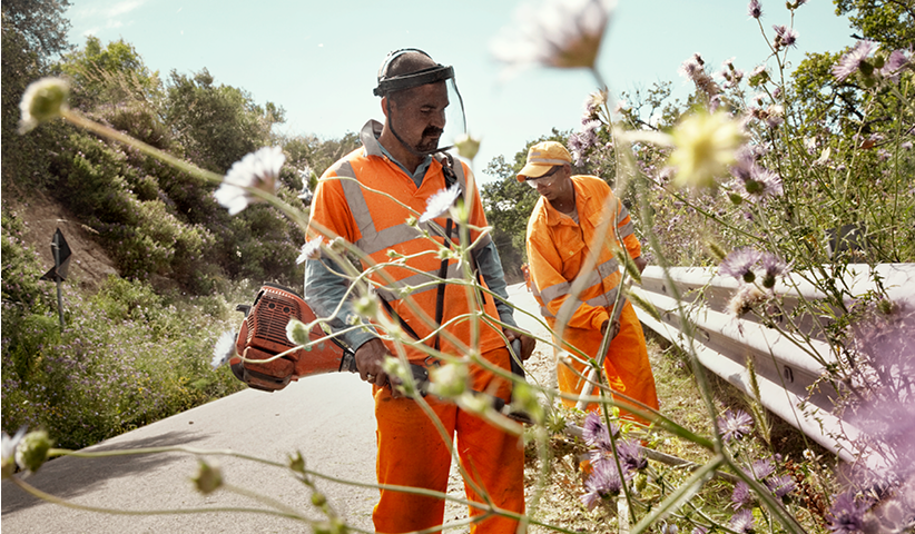 Workers mow a hard shoulder near Riace, Calabria