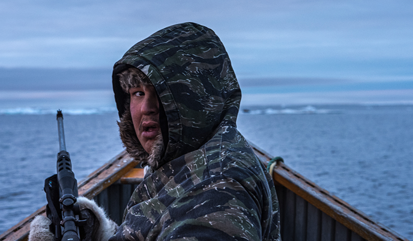 Ein Jäger horcht nach den Lauten einer Robbe, die er vom Boot aus angeschossen hat